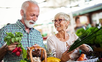 Senior couple smiling while shopping for vegetables