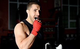 Man putting on mouthguard before boxing