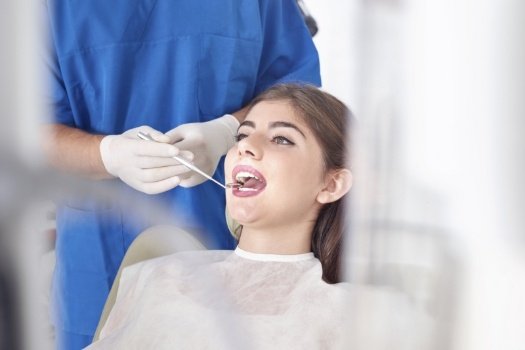 Dentist examining a patient's mouth with dental mirror