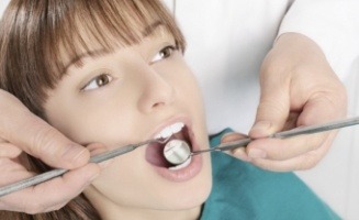 Dentist examining a patient's mouth with dental mirror