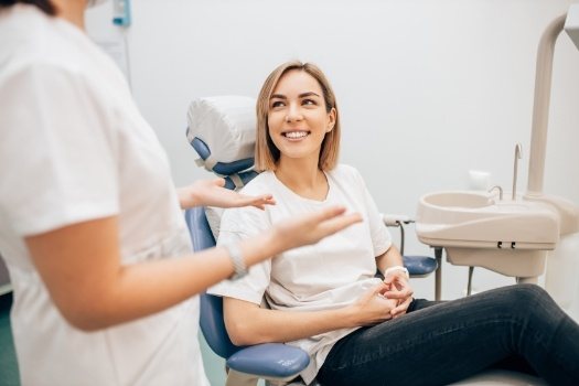 Smiling woman talking to dentist about restorative dentistry in Edison