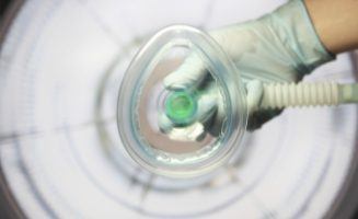 Dentist holding nitrous oxide sedation dentistry mask in front of camera