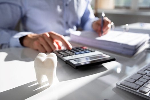 Tooth next to a man doing calculations