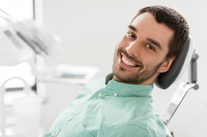 A smiling man sitting in a dentist’s chair